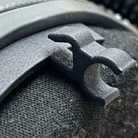 Thumbnail for Super close-up of Trac-Com Earbud Connector clip on carbon fiber helmet