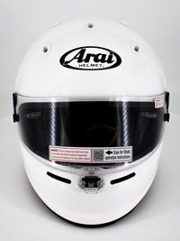 Thumbnail for A white Arai full-face racing helmet with a clear visor and black logo on a light gray background.