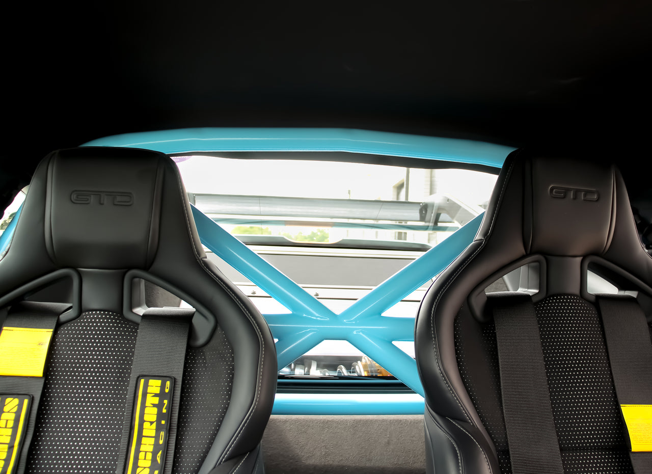 Mustang GTD interior with black racing seats featuring 'GTD' branding, schroth harnesees with yellow accents, and a CMS Roll bar