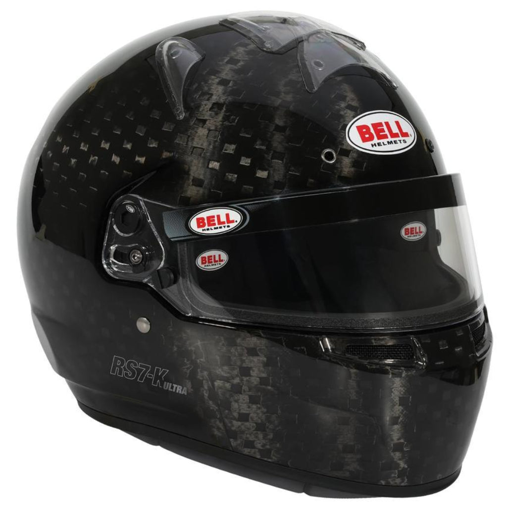 Angled view of Bell RS7-K ULTRA carbon helmet showing visor hardware, chin vent openings, and shell curvature image