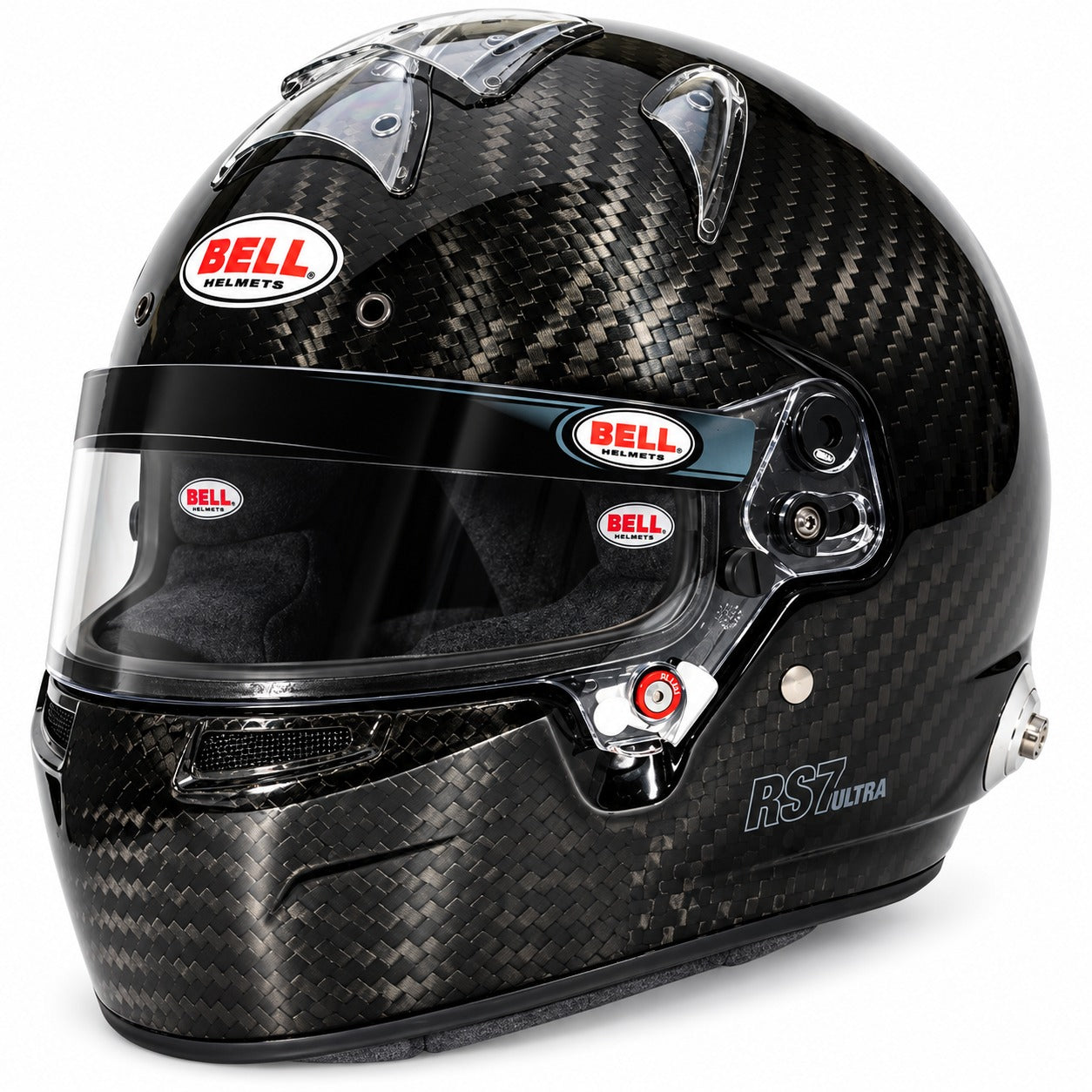 A Bell RST Ultra full-face racing helmet in a glossy black carbon fiber pattern, featuring a clear visor and multiple red and white Bell helmets logos.