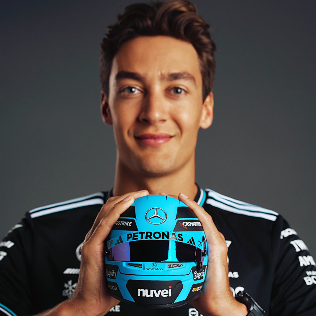 George Russell Formula 1 driver holding his Bell replica mini-helmet